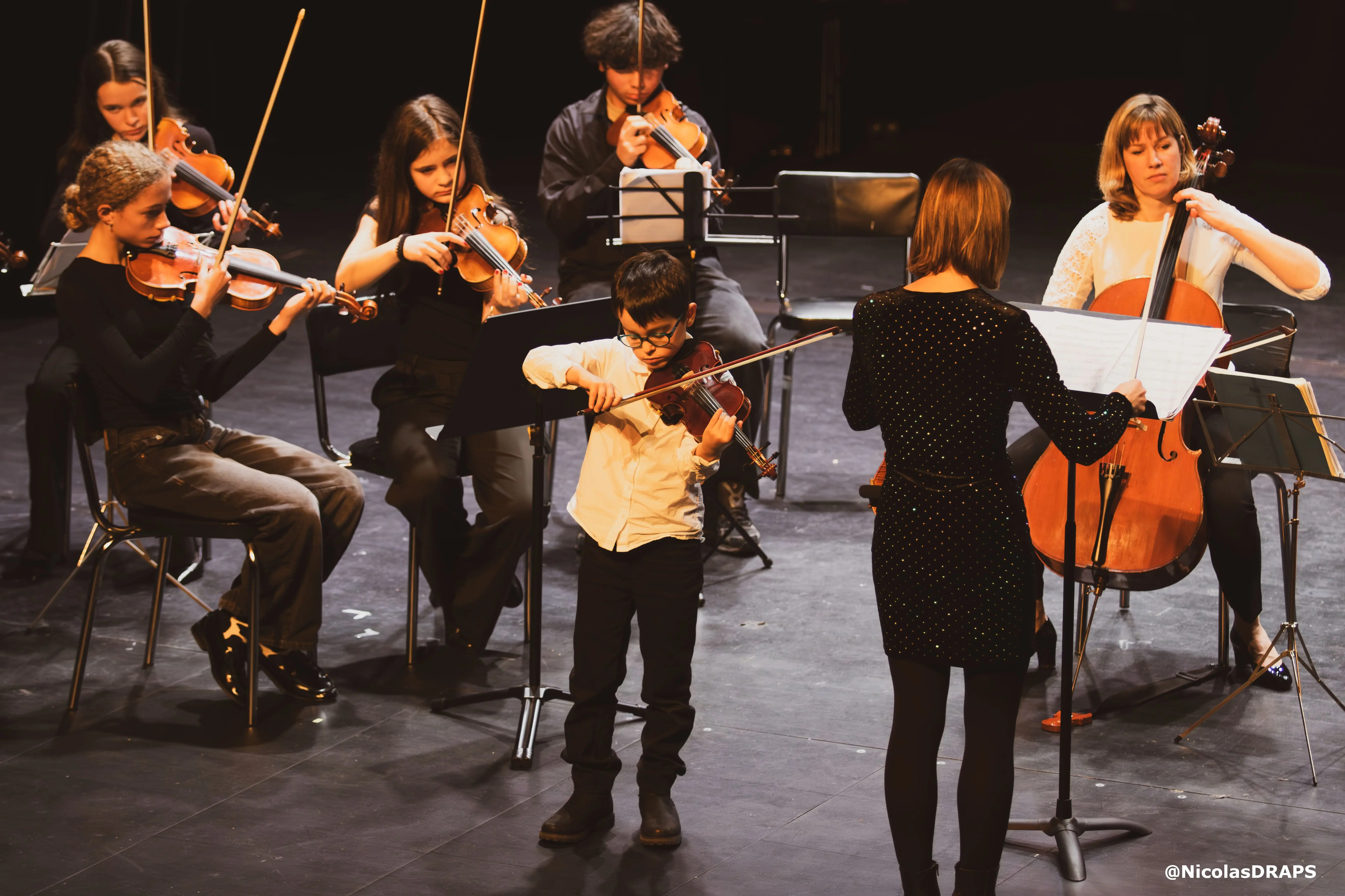 Un jeune élève de violon se produisant avec l'ensemble instrumental de l'académie.