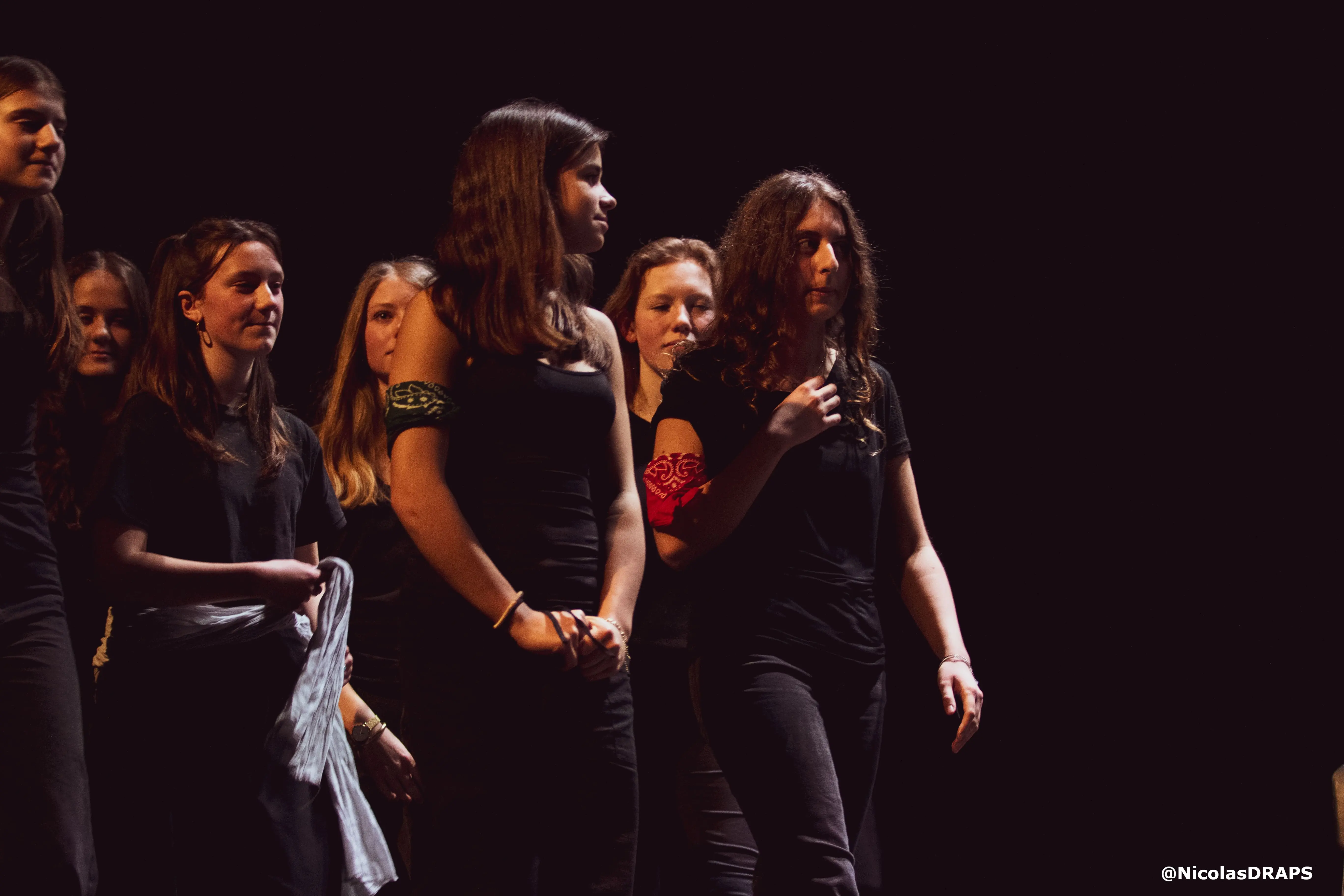 Un groupe d'adolescents sur une scène de théâtre, en plein spectacle.